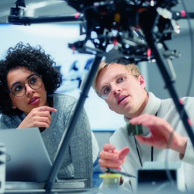 Two Diverse Developers Brainstorming and Programming. Working Together on a New Drone. Colleagues Building, Configuring and Testing Machines. Progressive Technologies Concept.