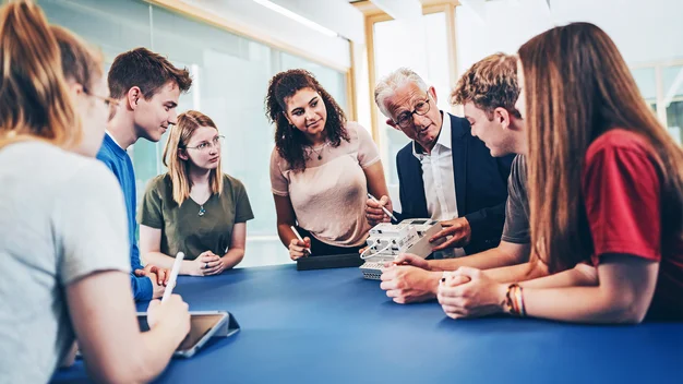 Hands-on im Smartgrid-Labor: Professor demonstriert einer Gruppe von Studierenden die Funktionsweise eines technischen Bauteils.
