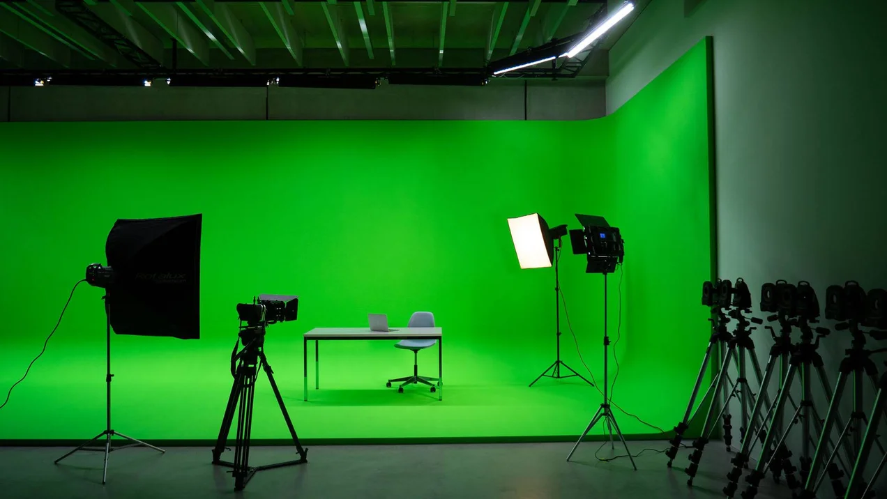 Photo setup with camera and lights in front of a large green screen