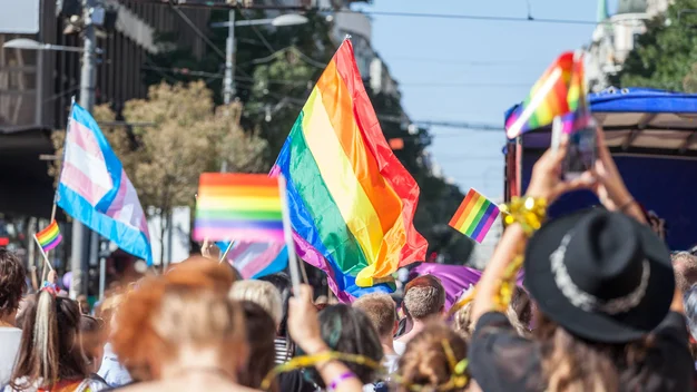 Menschenmenge mit Regenbogenflagge auf der Straße am Demonstrieren für Gleichberechtigung