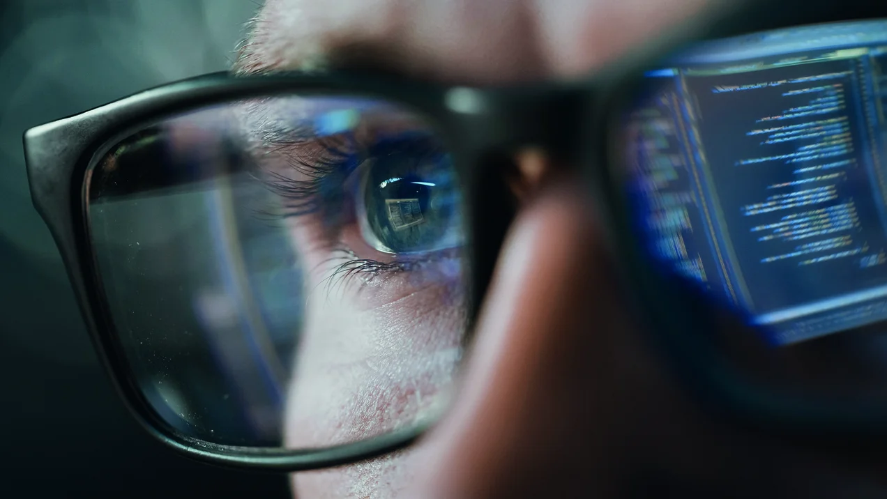 Close-up Portrait of Software Engineer Working on Computer, Line of Code Reflecting in Glasses. Developer Working on Innovative e-Commerce Application using Machine Learning, AI Algorithm, Big Data