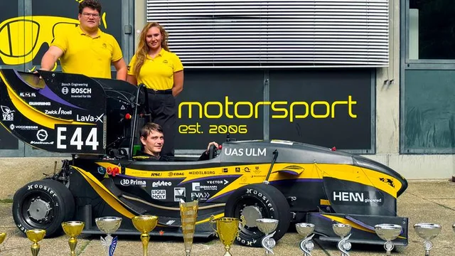 Das Team von Einstein Motorsport feiert mit seinem Rennwagen auf der Rennstrecke.