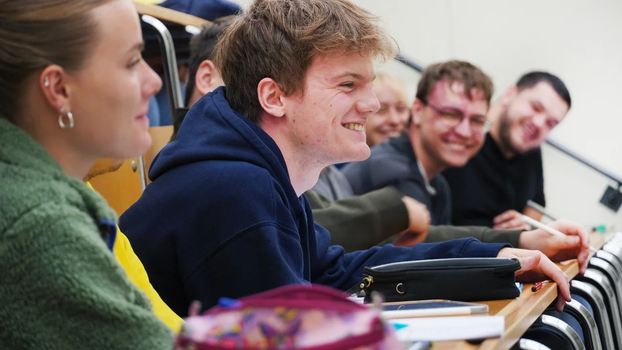 Studierende sitzen im Hörsaal und lachen