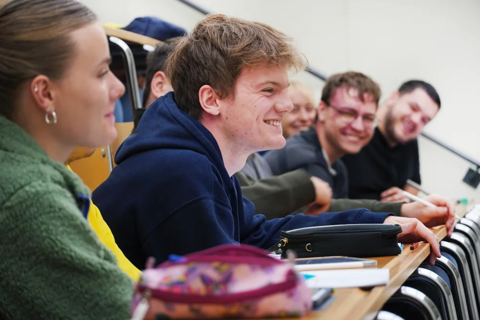 Studierende sitzen im Hörsaal und lachen