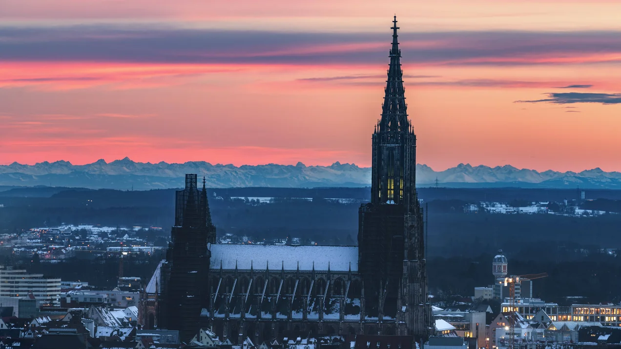 Ulmer Münster mit Alpenpanorama im Hintergrund.