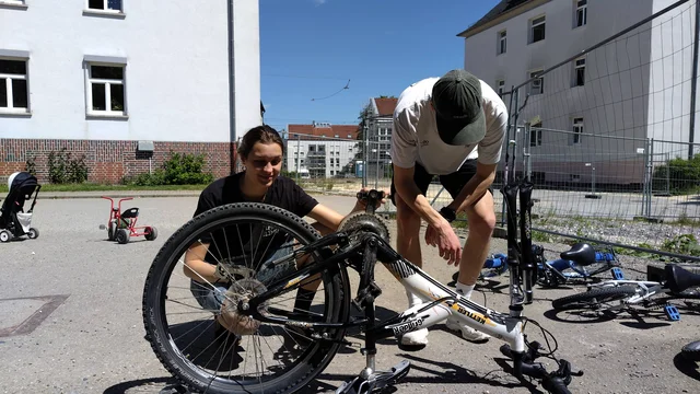 Zwei Studierende sind dabei ein Fahrrad zu reparieren