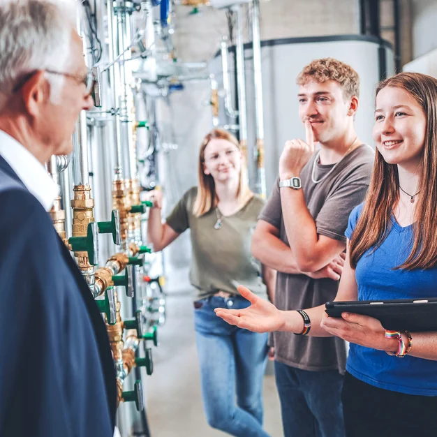 Praxisnahe Lehre im Speicherlabor: Professor und Studierende im direkten Austausch vor industriellen Anlagen.