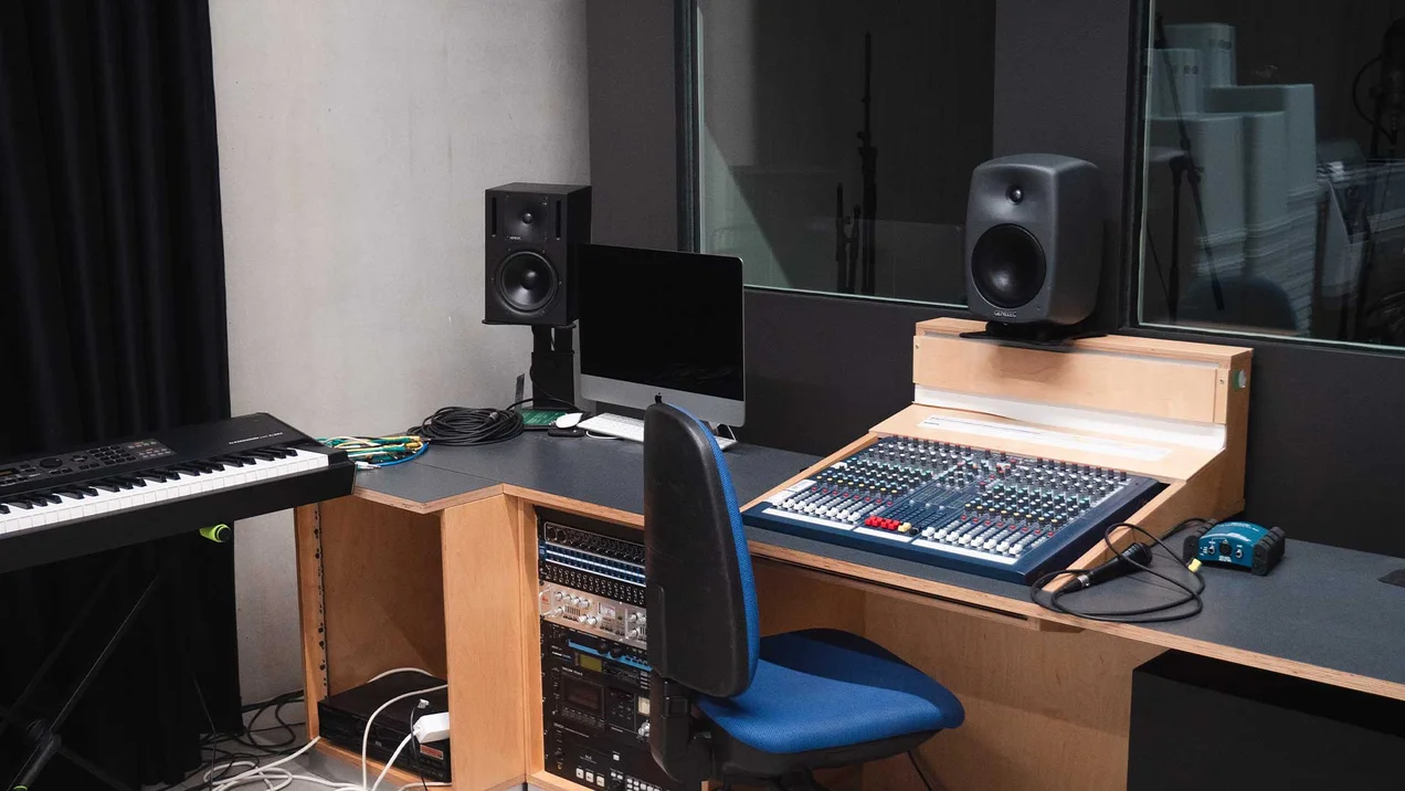 Recording studio with volume control, microphones and an electric piano