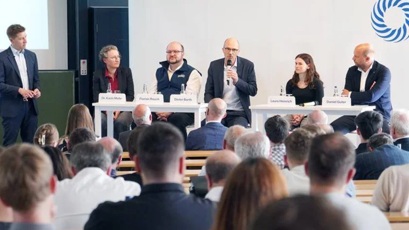 Personen vor Publikum, eine Person spricht