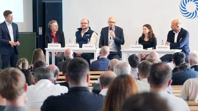 Personen vor Publikum, eine Person spricht