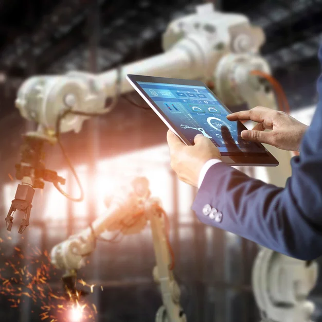 mensch in einer industriefertigungshalle, man sieht wie eine Maschine schweißt und ein Tablet für die Steuerung benutz wird