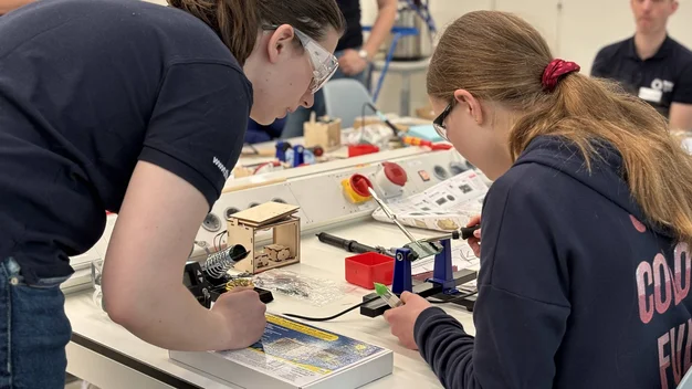 Das Foto zeigt eine Laborsituation mit einer Schülerin und einer Professorin.