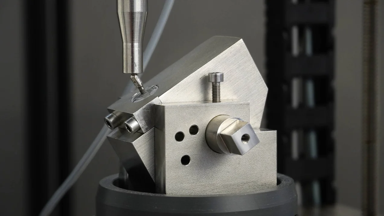 Zahnersatz Füllung wird mit Druck auf einem Metallblock getestet.