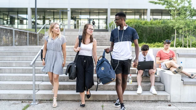 Studierende gehen eine breite Außentreppe auf dem Campus hinunter.