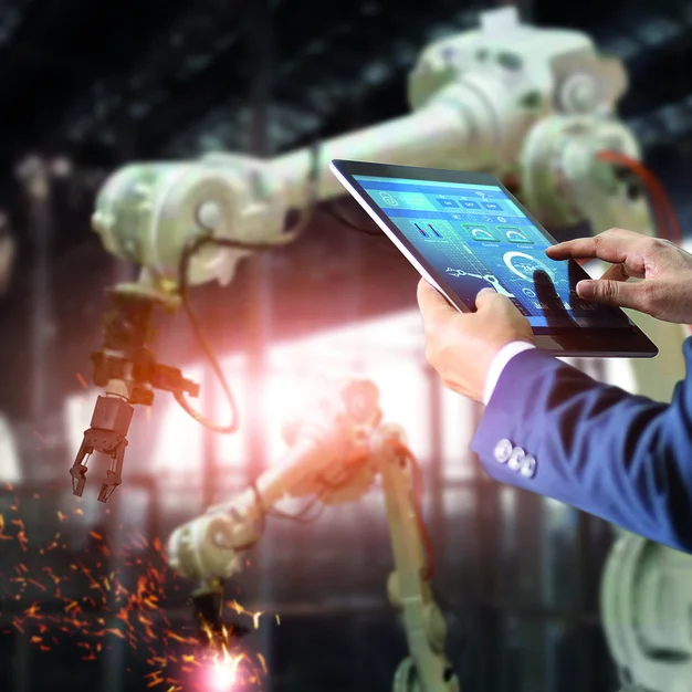 973143870 Manager industrial engineer using tablet check and control automation robot arms machine in intelligent factory industrial on real time monitoring system software. Welding robotics and digital manufacturing operation. Industry 4.0 concept